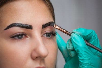 Vrouw die aanbrengen BrowTycoon Henna tint